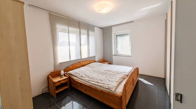 Schlafzimmer mit Fensterfront und Flächenvorhängen